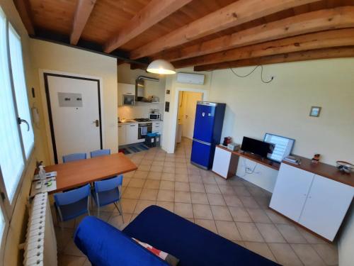 a kitchen and dining room with a table and blue chairs at Silenzioso, posto auto, 2km da Lodi, 30 km da Milano in San Martino In Strada