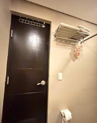 a black door in a bathroom with a toilet at Condo de Avila in Boracay