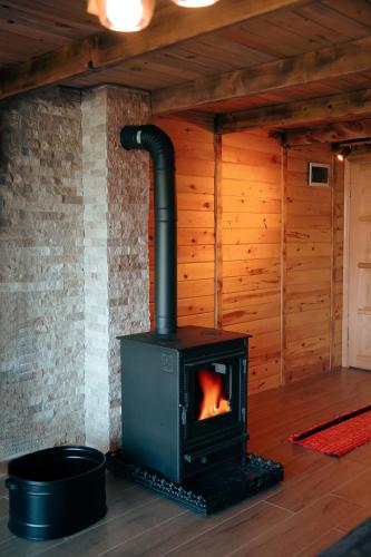 a wood stove in a room with a wall at Relax Dağ Evleri,Ayder yaylası in Dikkaya