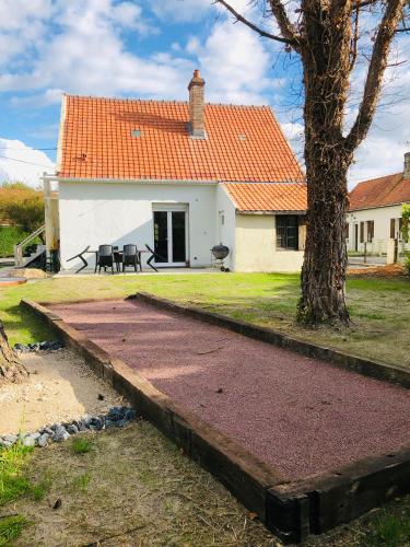 une maison blanche avec un toit orange dans l'établissement Gite du vieux Puits, à Merlimont