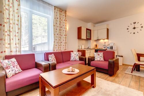Una sala de estar con dos sofás y una mesa. en MyPlace Pamporovo 2, en Pamporovo