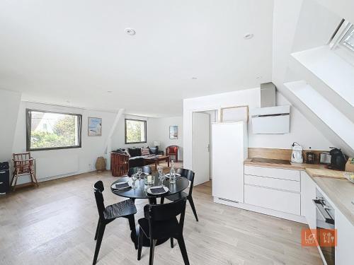 une cuisine et un salon avec une table et des chaises dans l'établissement La Terrasse : 1er étage villa proche plage, à Ambleteuse