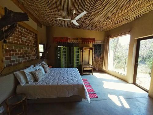 a bedroom with a bed and a ceiling fan at The Eco Hut in Hoedspruit