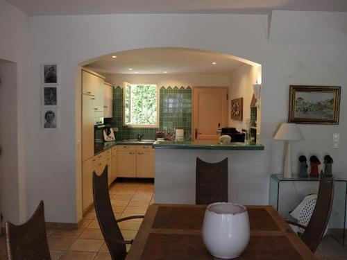 une cuisine et une salle à manger avec une table et un comptoir dans l'établissement Villa Équipée avec Jardin à 50m de la Plage et Commerces - FR-1-100-238, à Cavalaire-sur-Mer