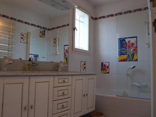 une salle de bain avec deux lavabos, une baignoire et un miroir dans l'établissement Villa Équipée avec Jardin à 50m de la Plage et Commerces - FR-1-100-238, à Cavalaire-sur-Mer