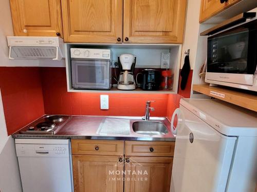 une petite cuisine avec un évier et un micro-ondes dans l'établissement Studio rénové de 26m² à Le Grand-Bornand pour 4 personnes - FR-1-458-116, au Grand-Bornand