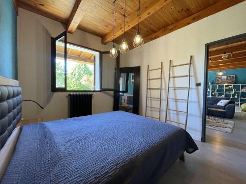 - une chambre avec un lit bleu et une échelle dans l'établissement Maison climatisée avec jardin près du centre de Vallon Pont d'Arc - 6 couchages - FR-1-382-112, à Vallon-Pont-dʼArc