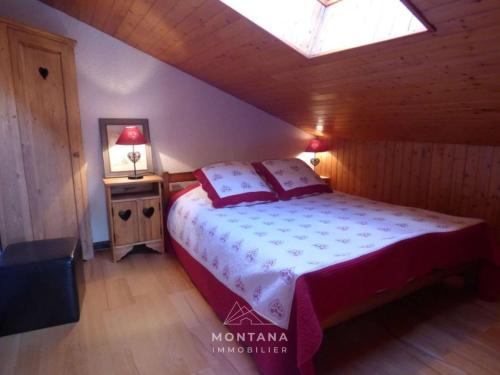 une chambre avec un lit et une lucarne dans l'établissement Agréable appartement montagnard pour 6 pers. proche commerces et télécabines - FR-1-458-149, au Grand-Bornand