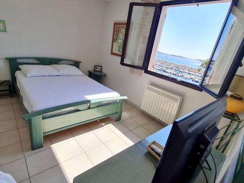 une chambre avec un lit et un bureau avec une télévision dans l'établissement T3 avec parking, piscine et tennis payants à 200m des plages - Wi-Fi - FR-1-316-335, à Six-Fours-les-Plages