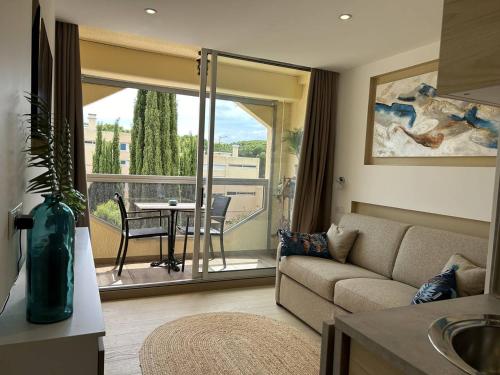un salon avec un canapé et une table dans l'établissement Studio climatisé à 200m de la plage avec balcon, parking et ménage inclus - Bormes-les-Mimosas - FR-1-251-836, à Bormes-les-Mimosas