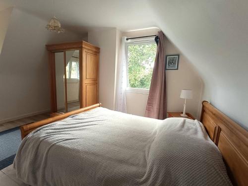 プルームール・ボドゥーにあるMaison avec WIFI, jardin clos, terrasse, à 600m de la plage - Pleumeur-Bodou - FR-1-368-425のベッドと窓のある寝室