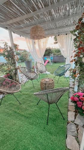 a group of chairs and a table in a yard at Villa SouAri 10' da Forte de Marmi - 2km spiaggia in Lido di Camaiore