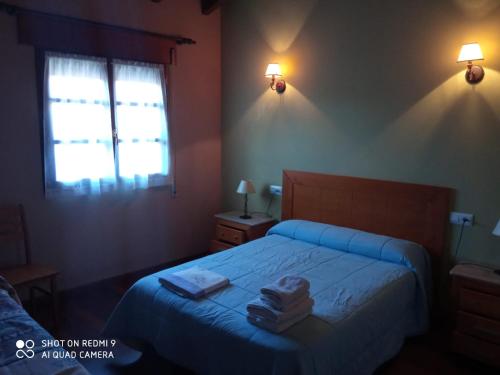 a bedroom with a bed with two towels on it at Casa Rural Llendelriu in Villahormes