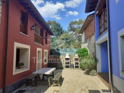 a bench sitting in a courtyard between two buildings at Casa Rural Llendelriu in Villahormes