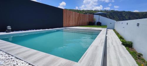 a swimming pool in the backyard of a house at Azure Sunset in Ponta Delgada
