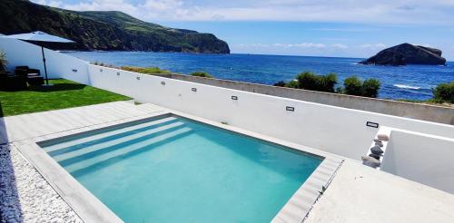 a swimming pool with a view of the ocean at Azure Sunset in Ponta Delgada