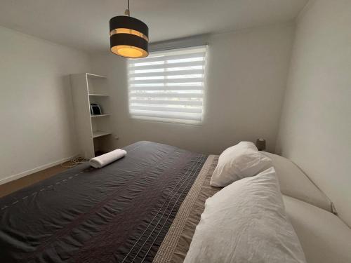 a bedroom with a large bed with a window at Casa acogedora en Romeral in Romeral