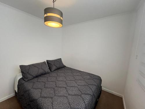 a bedroom with a bed in a room with a light at Casa acogedora en Romeral in Romeral