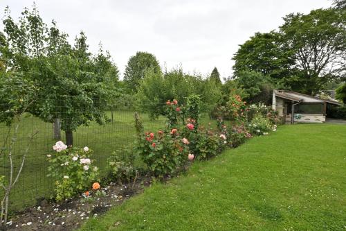 a garden with some flowers and a fence at Villa MANSART in Ver-sur-Launette