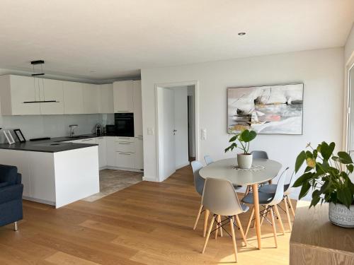 a kitchen and living room with a table and chairs at Gartenwohnung im modernen Stil in Unterkulm