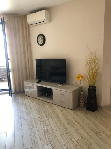 a living room with a flat screen tv on a entertainment center at Апартамент VESI комплекс ARTUR in Sveti Vlas