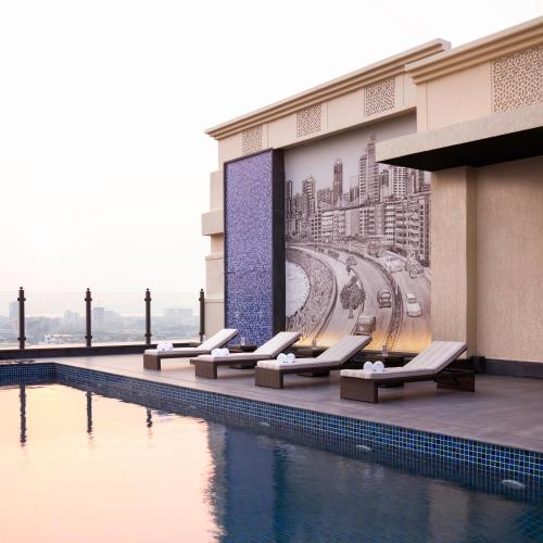 a hotel with a pool and a mural of a city at Navi Mumbai Marriott in Navi Mumbai