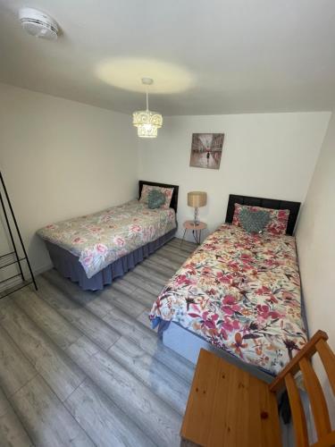 a bedroom with two beds and a table at 2 Bedroom Apartment on suite bathroom, Southmead Bristol in Bristol