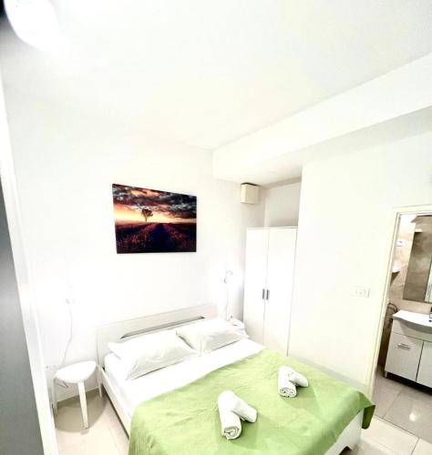a white bedroom with a bed and two towels at Morska in Orebić
