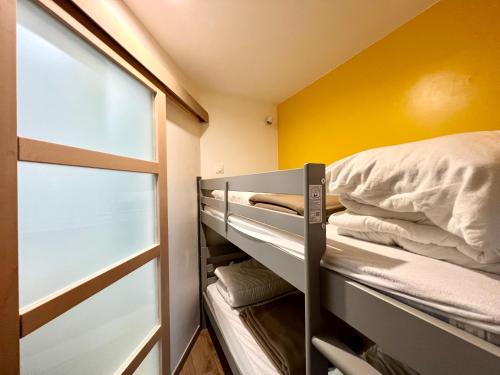 - une chambre avec des lits superposés et un mur jaune dans l'établissement Magnifique appartement vue mer 4 personnes, à La Tranche-sur-Mer