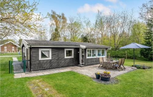 EskebjergにあるStunning Home In Eskebjerg With Kitchenの小さなキャビン(テーブル、傘付)