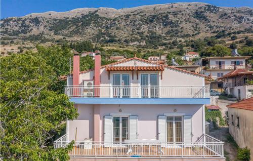 a pink house with a balcony and mountains in the background at Lovely Home In Patra With Kitchen in Patra