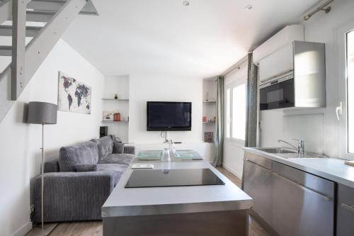 Il dispose d'une cuisine et d'un salon avec un canapé et un évier. dans l'établissement Croisette Escape - Wifi - Clim - Hypercentre, à Cannes
