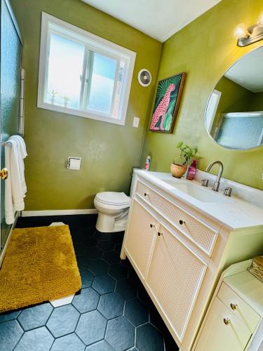 a bathroom with a sink and a toilet and a mirror at Colorful 50's Ranch in the Heart of Eugene in Eugene