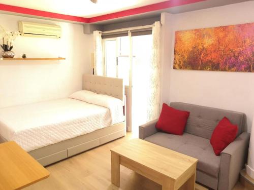 ein Schlafzimmer mit einem Bett, einer Couch und einem Tisch in der Unterkunft Acogedor Apartamento Entero in Arcos de la Frontera