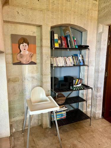 a room with a chair and a book shelf with books at Villa CARAMEL - Piscine - VUE in Fargues