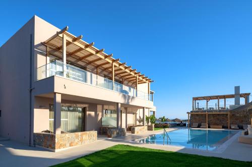 una casa con piscina al lado de un edificio en High Beach White - Adults Only, en Malia