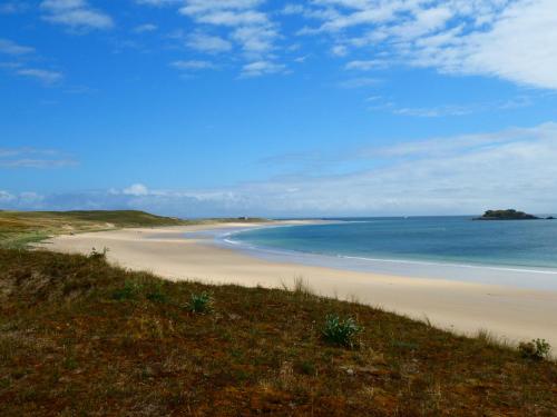 a sandy beach with the ocean in the background at Ti Glas in Grand-Champ