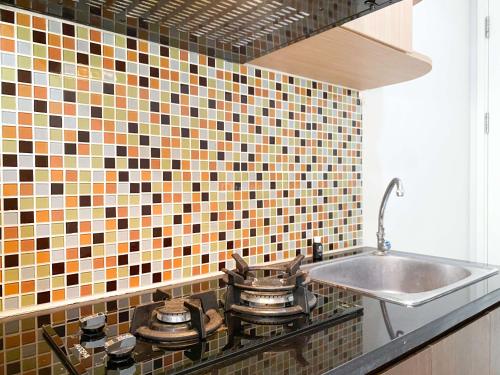 eine Küchentheke mit Töpfen und Pfannen auf einem Herd in der Unterkunft Great Deal Studio at Springlake Summarecon Bekasi Apartment By Travelio in Bekasi