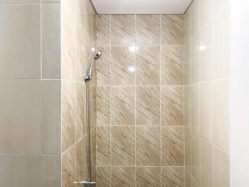 a shower with a glass door in a bathroom at Comfort 2BR at Transpark Juanda Bekasi Timur Apartment By Travelio in Bekasi
