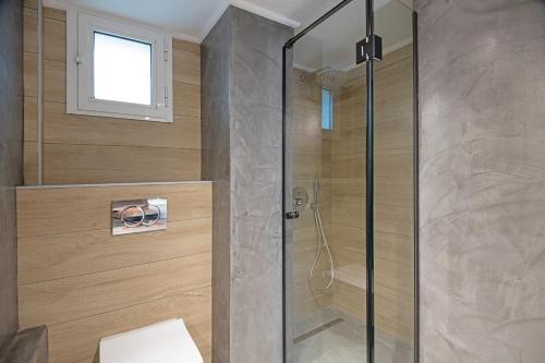 a shower with a glass door in a bathroom at Seastone Beach Houses Pefkohori in Pefkohori