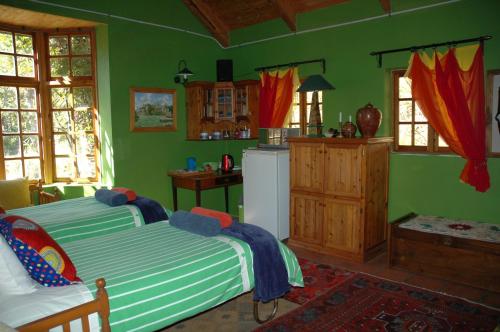 a green room with a bed and a kitchen at La Motte B&B in Bethlehem