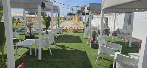 フォッローニカにあるLuci Sul Mare -Boutique Roomsの芝生の白い椅子とテーブル