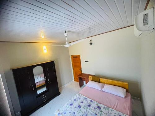 une petite chambre avec un lit et un miroir dans l'établissement Sunset Chalet, à Mullaittivu