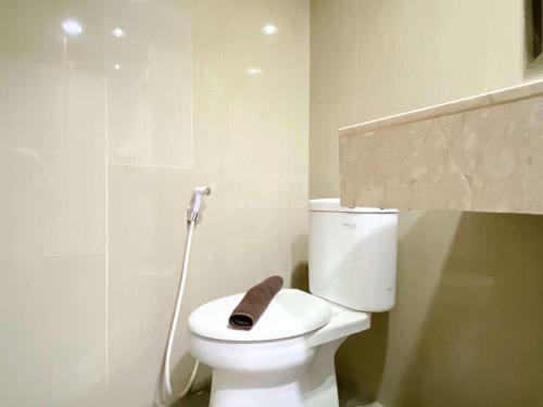 a bathroom with a toilet with a brown towel on it at Comfort Stay and Homey 2BR Apartment at H Residence By Travelio in Jakarta