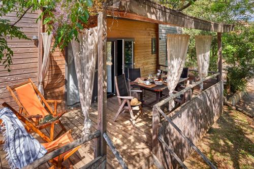 a patio with a table and chairs and a house at Au Paradis des Campeurs in Les Issambres