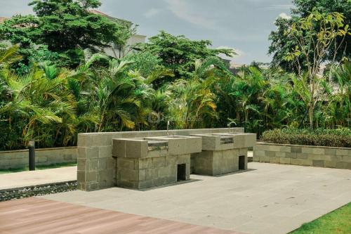 a stone bench in the middle of a park at Good and Comfy 1BR (No Kitchen) at Citra Living Apartment By Travelio in Jakarta
