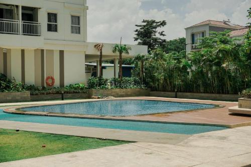 a swimming pool in front of a house at Good and Comfy 1BR (No Kitchen) at Citra Living Apartment By Travelio in Jakarta