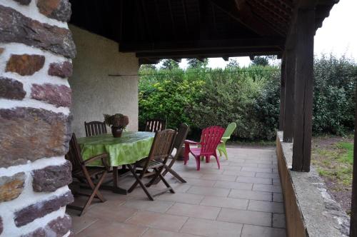 a patio with a table and chairs on a patio at La Demeure de Merlin l'Enchanteur in Loscouët-sur-Meu