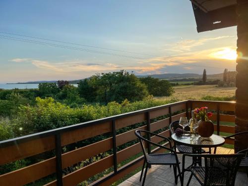 a table and chairs on a balcony with a view at Villa Sajkod in Tihany