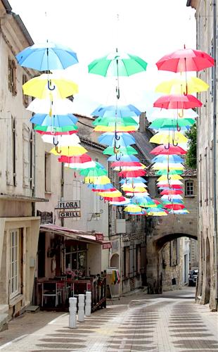 a bunch of umbrellas hanging over a city street at Villa CARAMEL - Piscine - VUE in Fargues